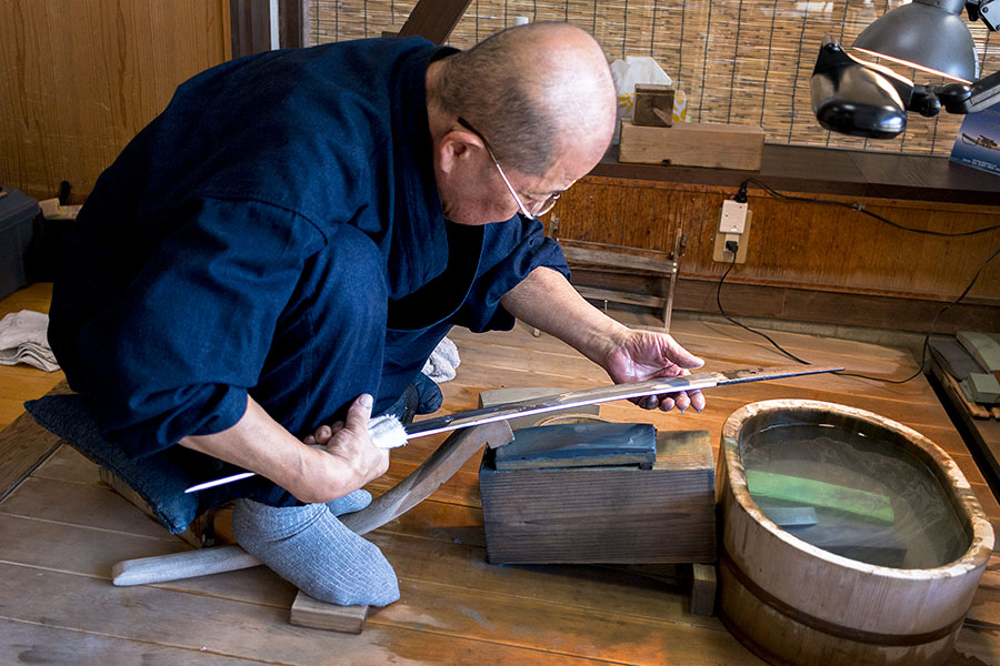 Takayama Toshio, sword polisher and sharpener, works the blade of a hand-forged katana sword at the Bizen Osafune Sword Museum in Osafune, Japan.