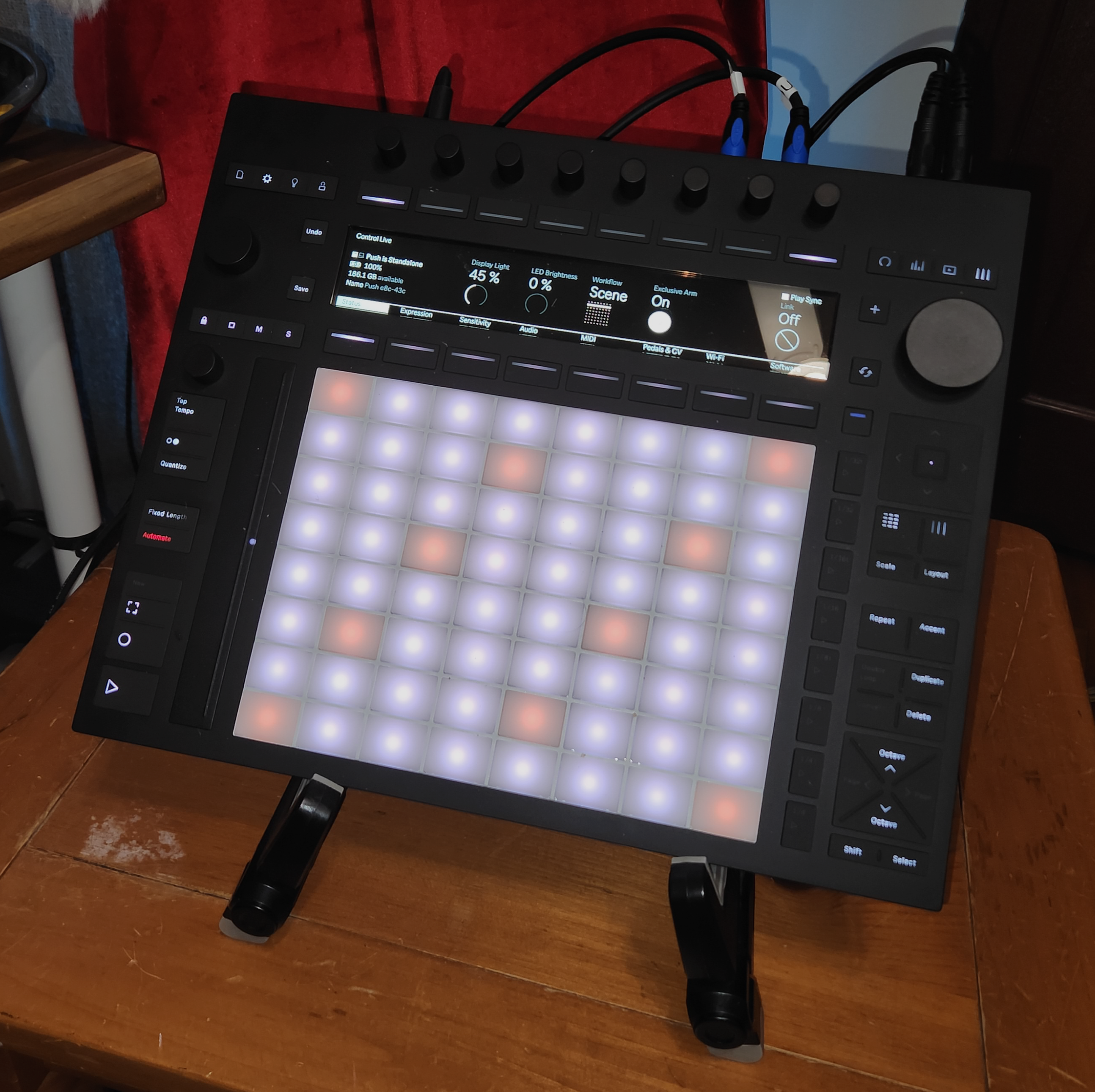 Ableton Push 3 Standalone, tilted back on a folding guitar stand